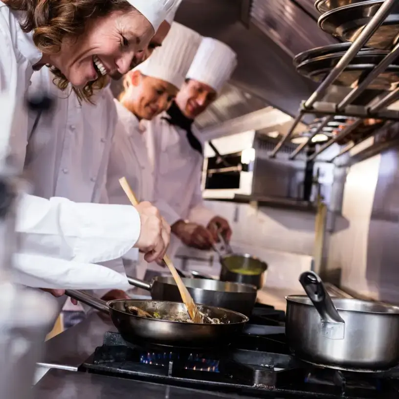 Chefs cooking on commercial stove